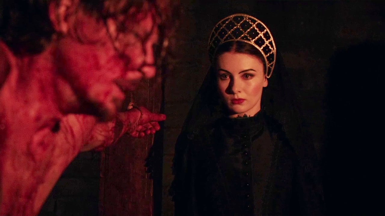 Megan Tremethick in a gold headdress and dark veil in The Reign of Queen Ginnarra